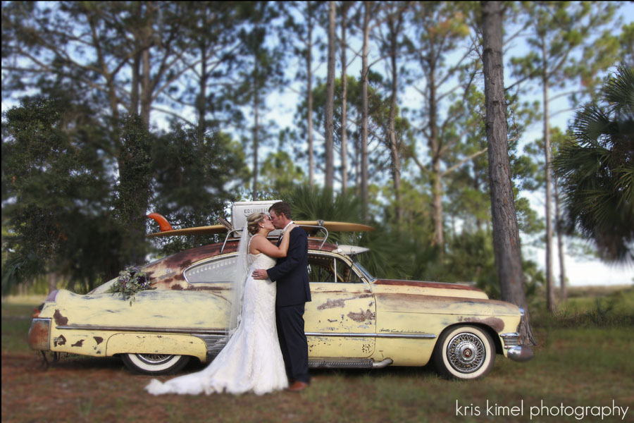 bride and groom posing in front of vintage car and surfboard