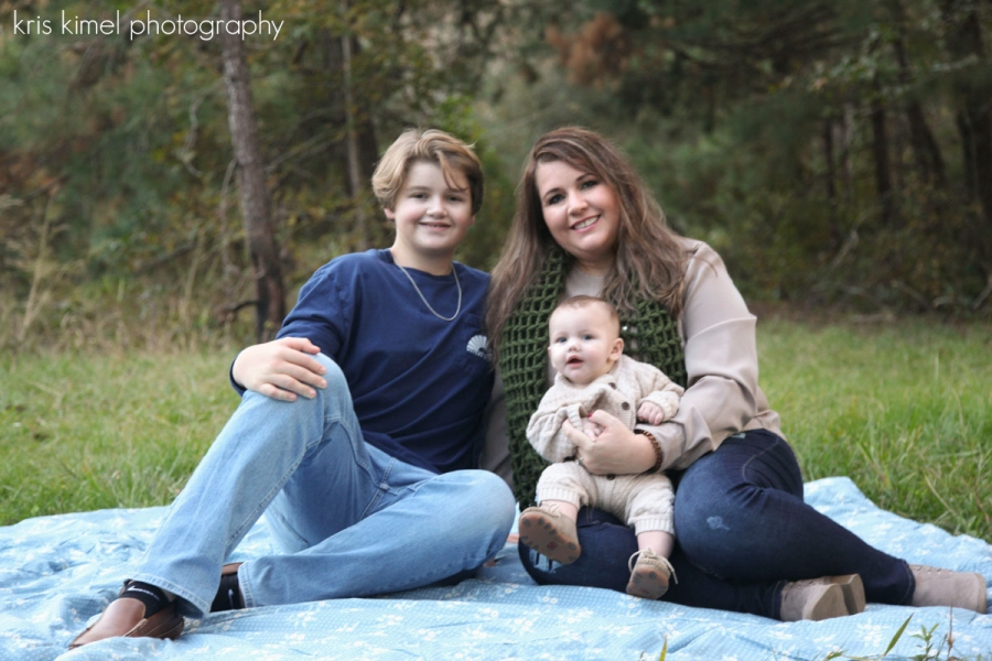 portrait of mother and sons on a blanket in a field