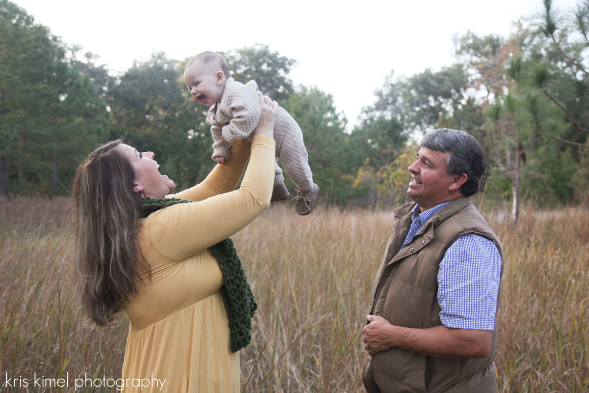 portrait of happy family playing with baby