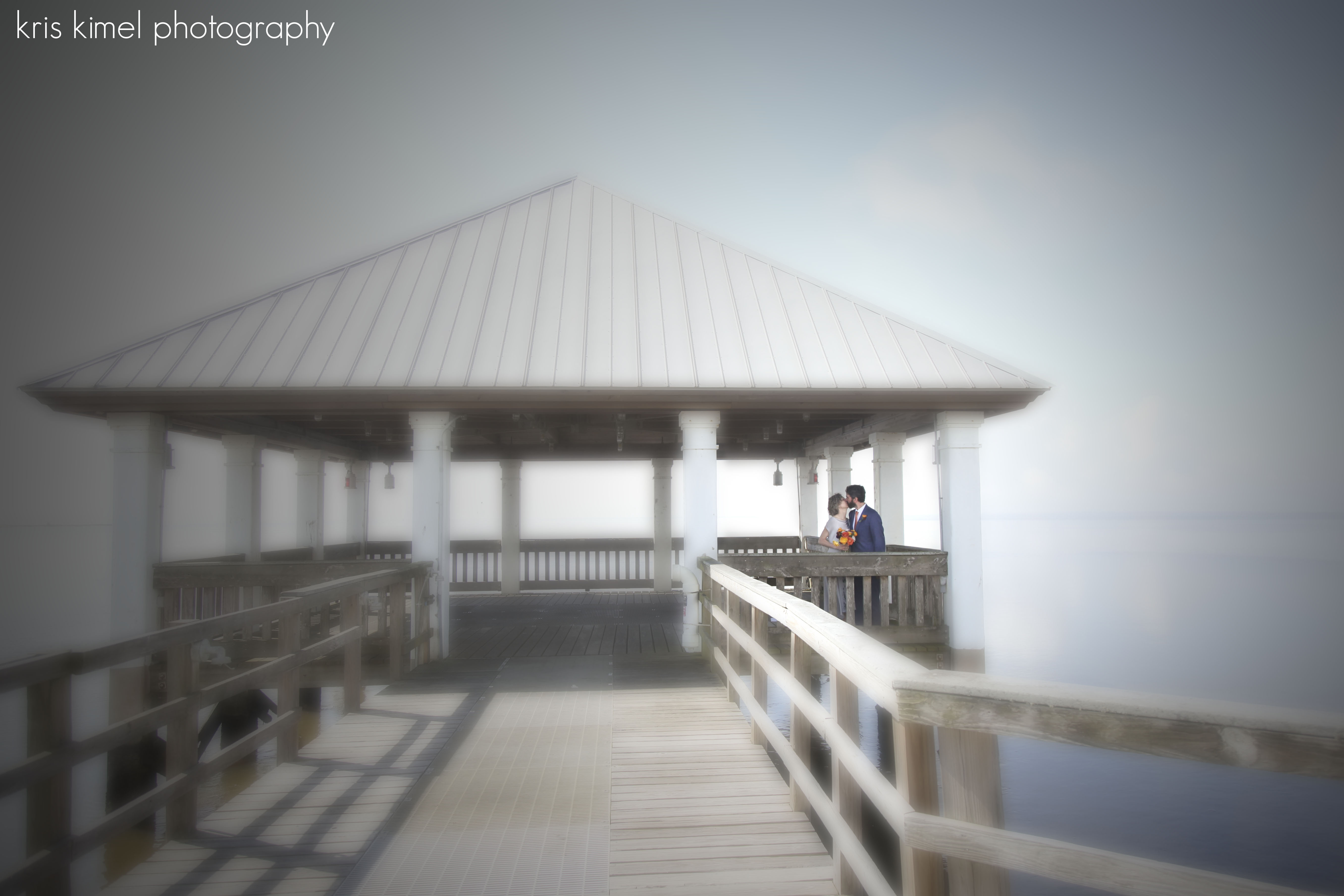 photo of bride and groom kissing on pier in Apalachicola, FL