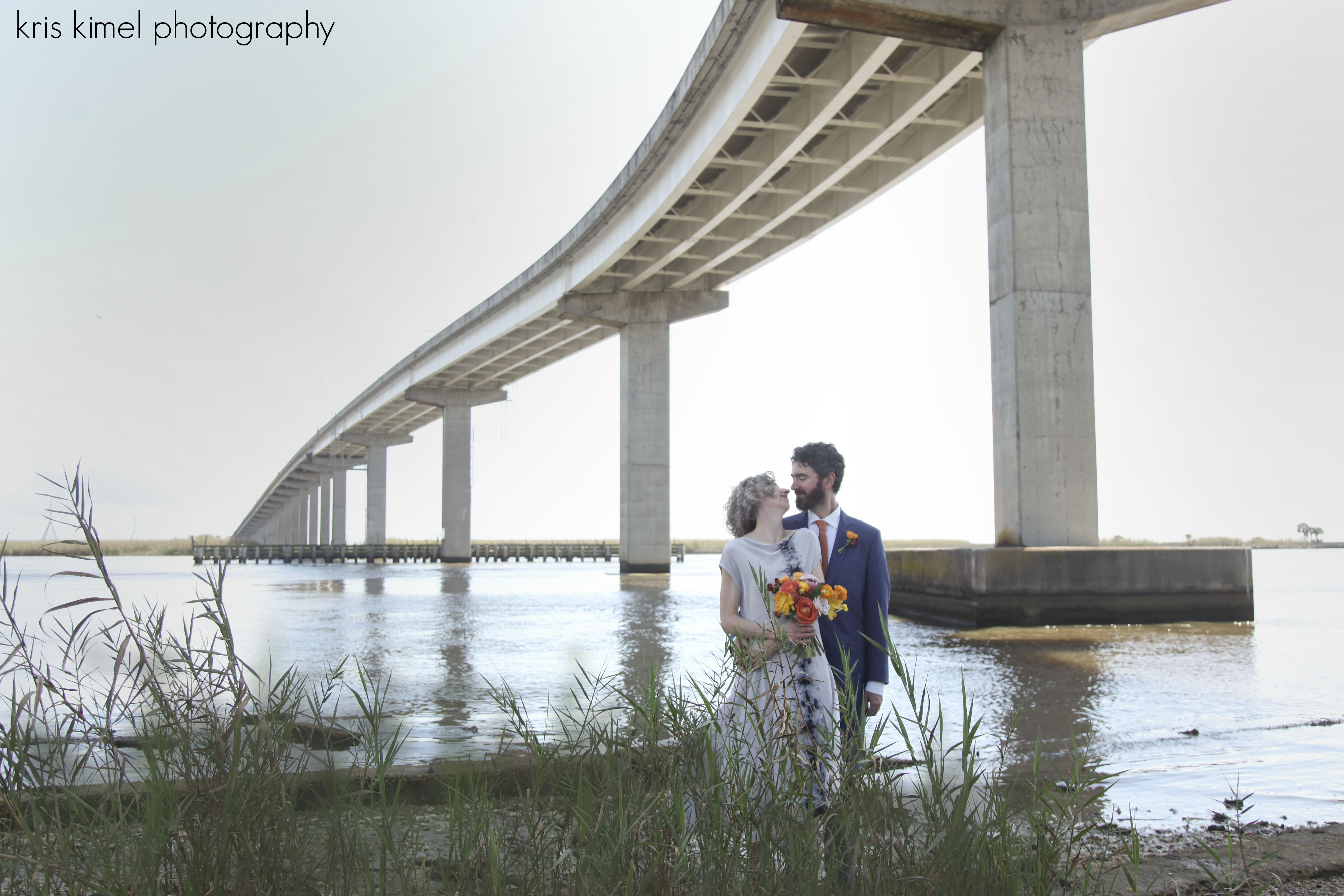 Portrait of bride and groom near bridge in Apalachicola, FL