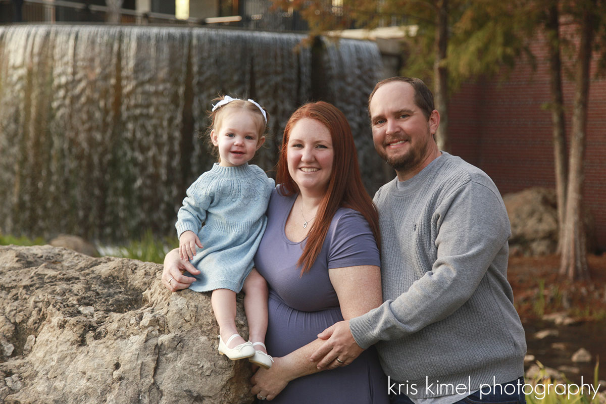 Portrait of a family in front of the waterfall at Cascades Park in Tallahassee, FL by Kris Kimel Photography